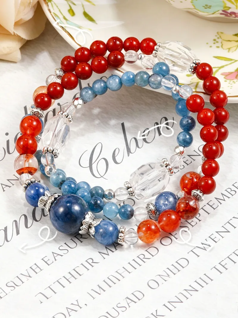 Hand wearing the Trifid Nebula art healing creation featuring kyanite, red agate, clear quartz, and red resin flower crystals