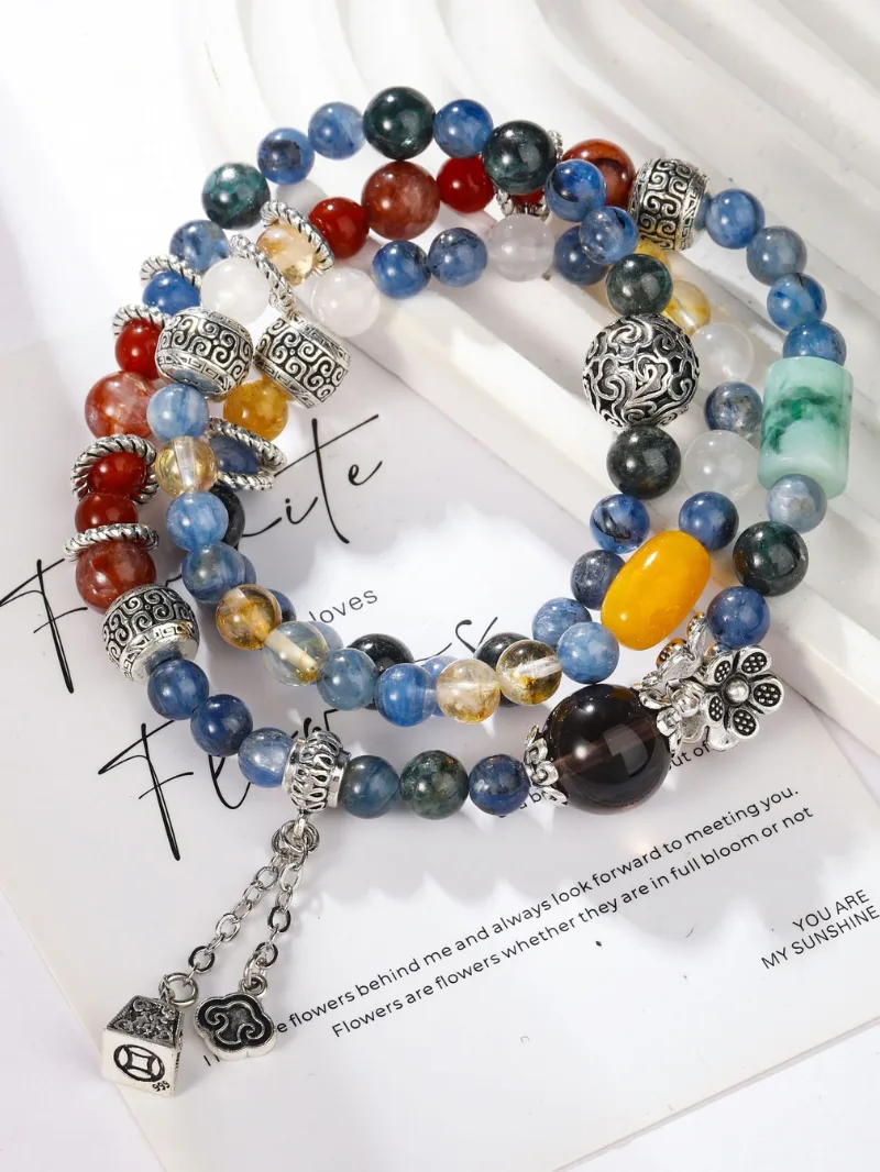 Hand wearing the Orion Nebula art healing creation featuring red agate, kyanite, green phantom quartz, citrine, smoky quartz, and clear quartz