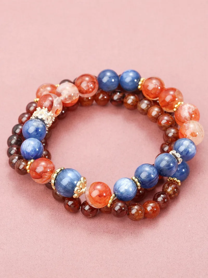Hand wearing the Lagoon Nebula art healing creation featuring burgundy garnet, kyanite, and red resin flower crystals